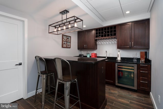bar featuring baseboards, wet bar, recessed lighting, wood tiled floor, and beverage cooler