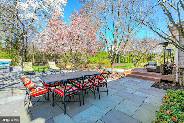 view of patio with outdoor dining space and a wooden deck