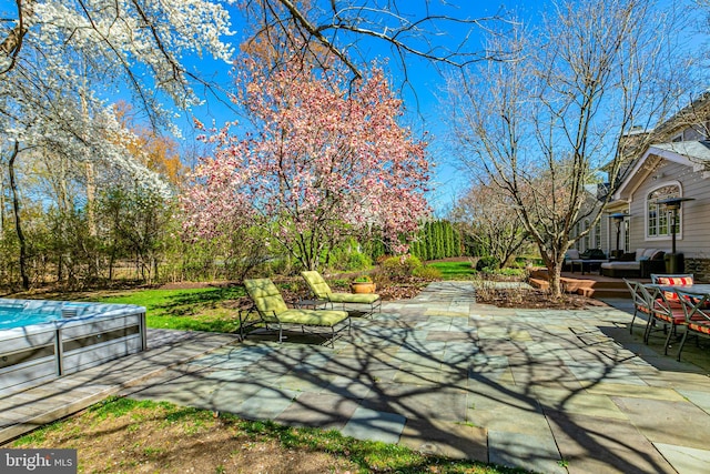 view of patio with fence and an outdoor hot tub