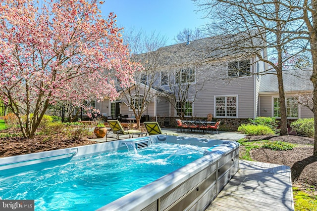 view of pool featuring an outdoor hot tub