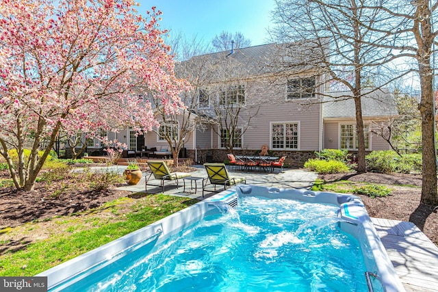 view of swimming pool featuring a patio area and an outdoor hot tub