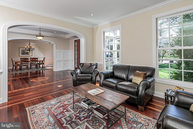 living room with arched walkways, wood finished floors, and a wealth of natural light