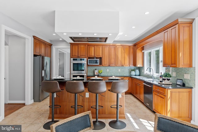 5325 Sandy Point Ln, Clifton, VA 20124 - kitchen with appliances with stainless steel finishes, a sink, decorative backsplash, recessed lighting, and a kitchen bar