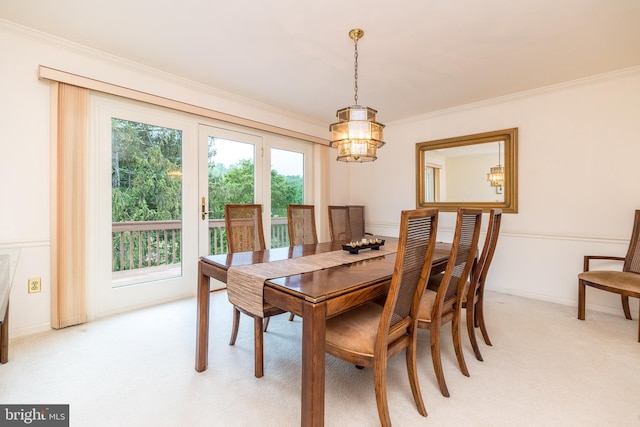 dining area with light carpet, ornamental molding, healthy amount of natural light, and a chandelier
