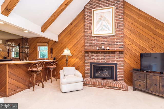 carpeted living area featuring wood walls, a brick fireplace, and bar area