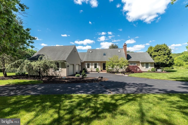cape cod house with a garage, a front lawn, a chimney, and asphalt driveway