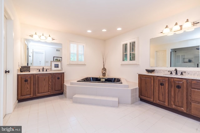 full bath featuring tile patterned floors, two vanities, recessed lighting, and a garden tub