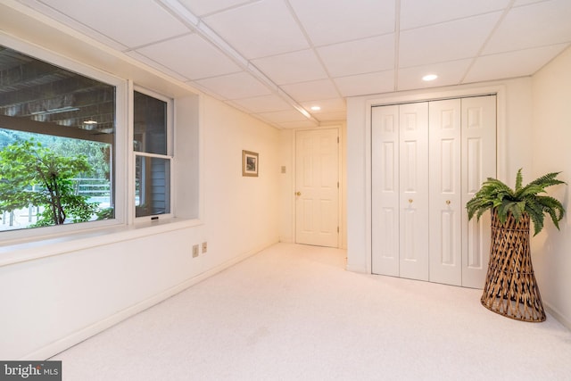 unfurnished bedroom featuring carpet flooring, recessed lighting, a closet, a drop ceiling, and baseboards