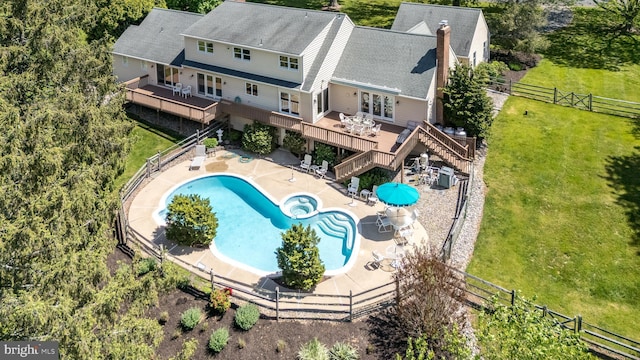 view of subject property with a pool and a tree filled landscape