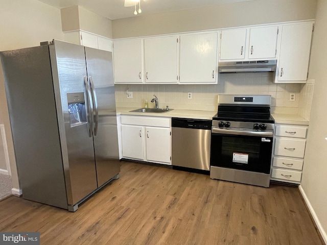 7944 Tick Neck Rd, Pasadena, MD 21122 - kitchen with appliances with stainless steel finishes, under cabinet range hood, a sink, and light wood-style flooring