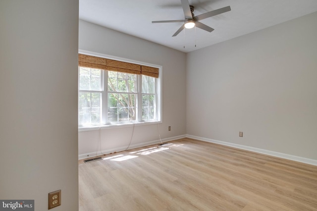 unfurnished room with baseboards, a ceiling fan, light wood-style flooring, and visible vents