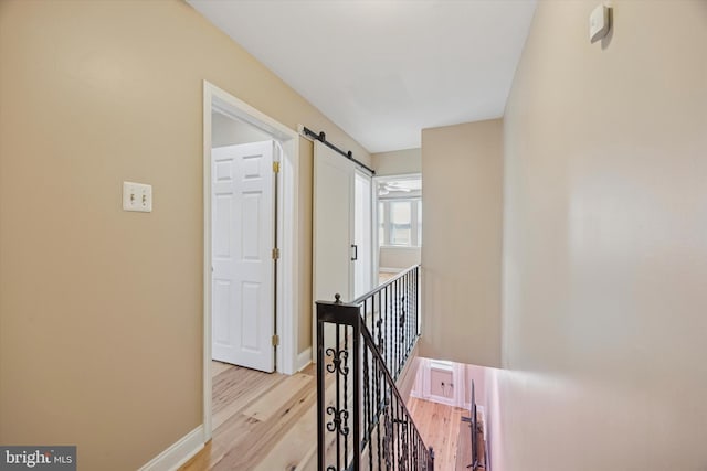 5223 Pentridge St, Philadelphia, PA 19143 - hall with an upstairs landing, light wood-style flooring, baseboards, and a barn door
