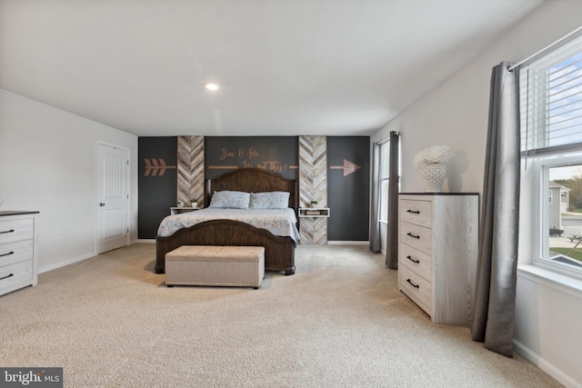 bedroom featuring multiple windows, light colored carpet, and baseboards