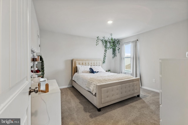bedroom featuring baseboards and light carpet