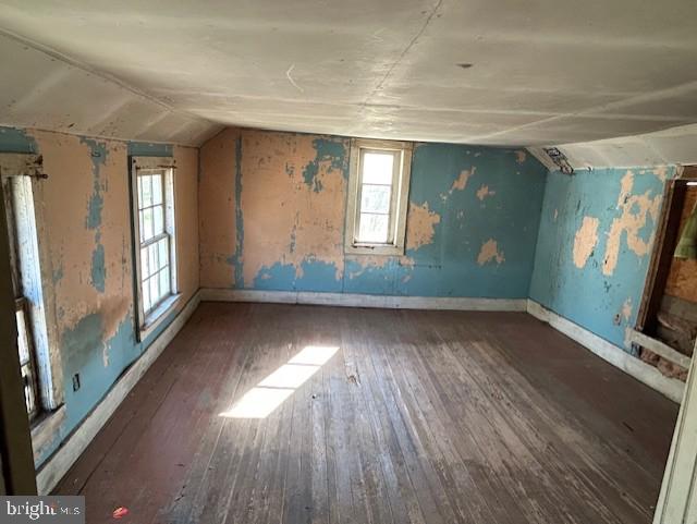 bonus room featuring vaulted ceiling, hardwood / wood-style floors, and baseboards