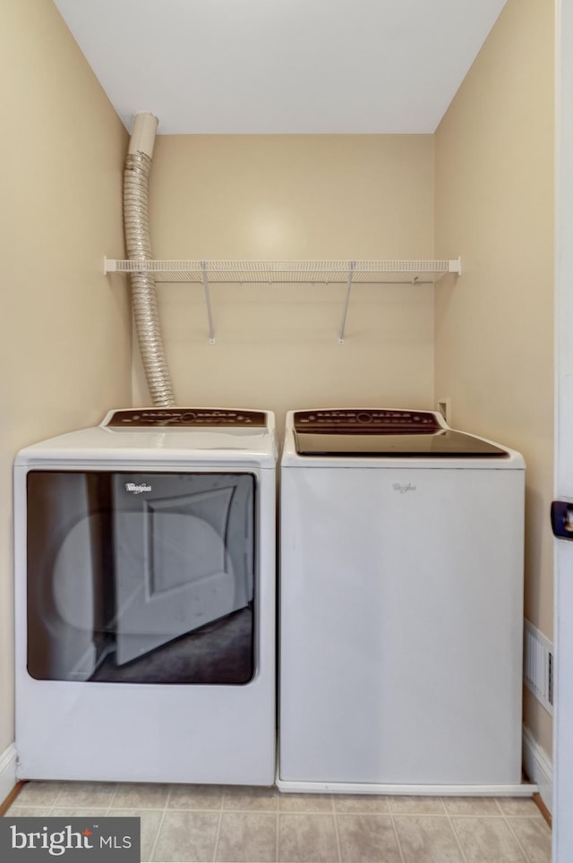 washroom featuring baseboards, laundry area, and washing machine and dryer