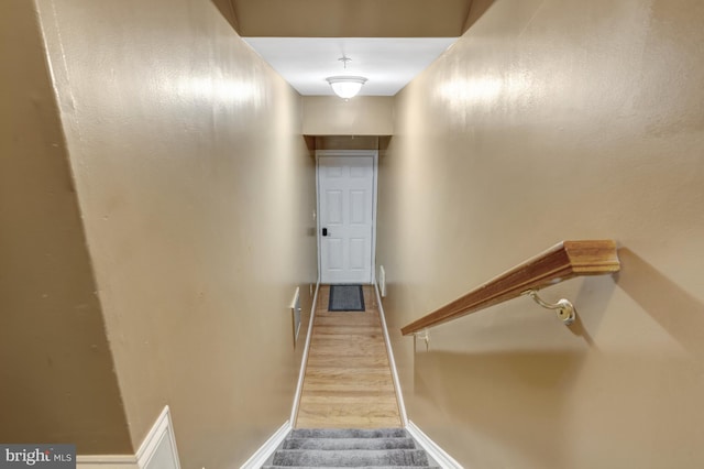 stairway with baseboards and wood finished floors