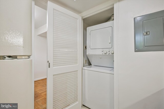 washroom with stacked washing machine and dryer and electric panel