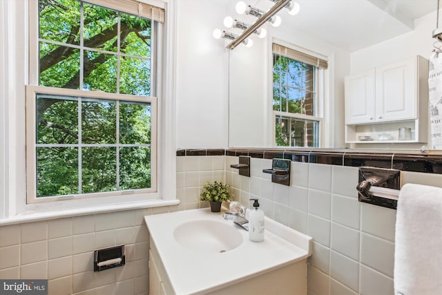 bathroom featuring vanity and tile walls