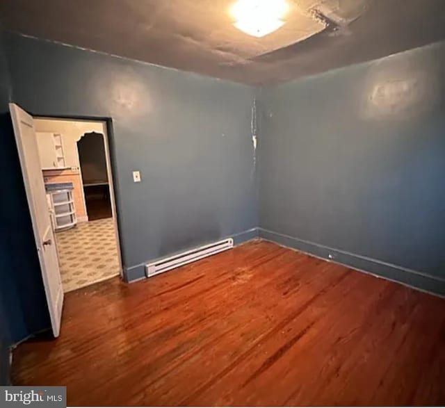 1911 Mckean St, Philadelphia, PA 19145 - spare room with a baseboard radiator, wood finished floors, and baseboards