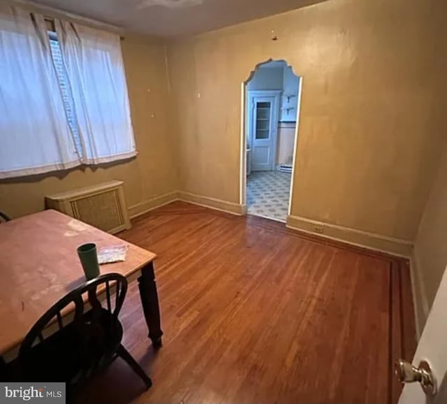 1911 Mckean St, Philadelphia, PA 19145 - interior space featuring radiator heating unit, arched walkways, baseboards, and wood finished floors