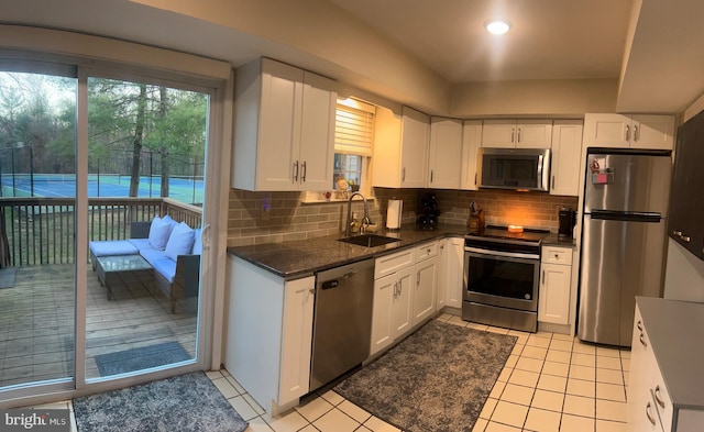 1646 Mcnelis Dr, Southampton, PA 18966 - kitchen featuring light tile patterned floors, tasteful backsplash, white cabinets, a sink, and stainless steel appliances