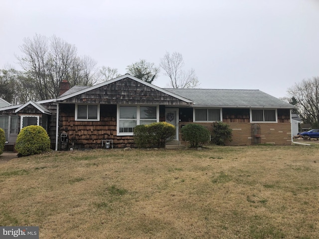 single story home featuring roof with shingles and a front lawn