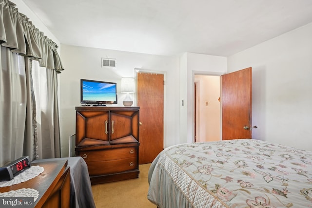 bedroom featuring visible vents and light carpet