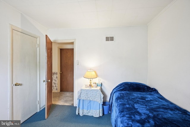 carpeted bedroom with visible vents and crown molding
