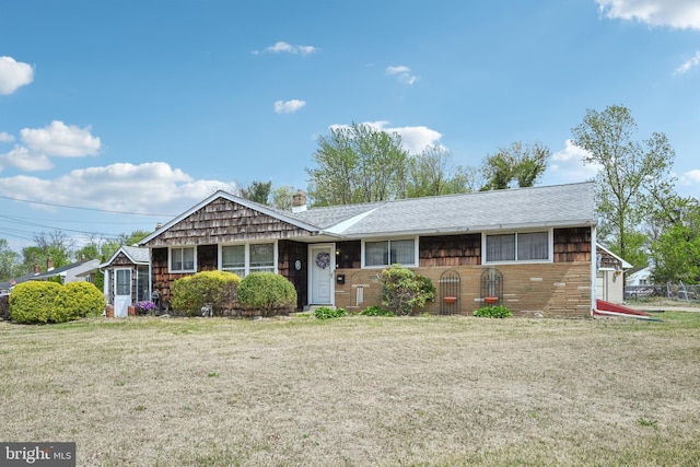 ranch-style home with a chimney, a front lawn, and brick siding