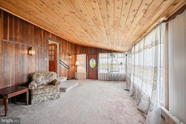 living area with lofted ceiling, carpet flooring, wood walls, and wooden ceiling