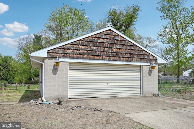 detached garage featuring fence