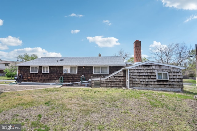rear view of property featuring a chimney and a yard