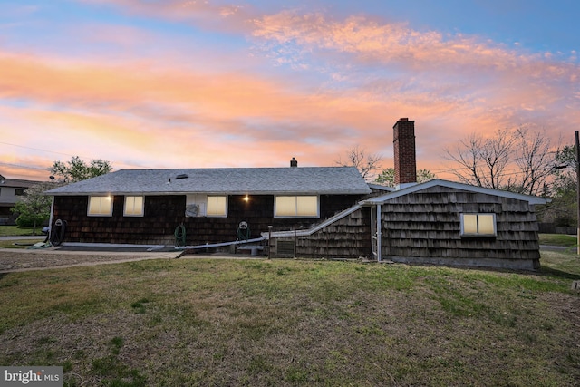 view of front of property featuring a chimney and a yard
