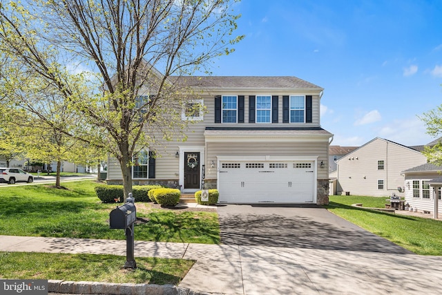 view of front of property featuring an attached garage, driveway, and a front yard