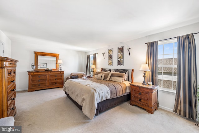 bedroom with baseboards and light colored carpet