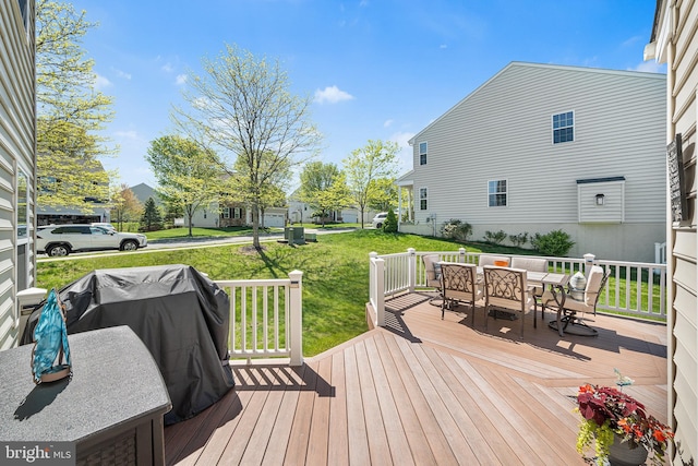 wooden deck with a yard and outdoor dining space
