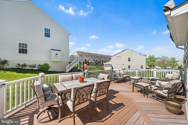 wooden terrace with a yard and outdoor dining space