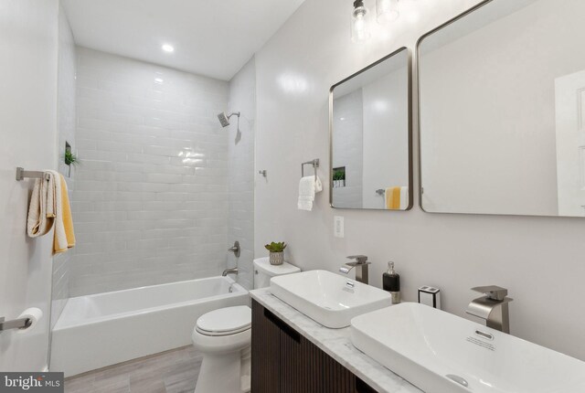 5707 Colorado Ave NW, Washington, DC 20011 - full bathroom with a sink, double vanity, toilet, shower / bath combination, and wood finished floors
