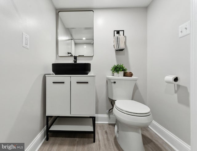 5707 Colorado Ave NW, Washington, DC 20011 - half bathroom with baseboards, toilet, vanity, and wood finished floors