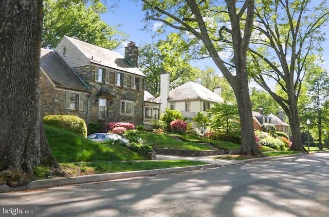 4817 Rodman St NW, Washington, DC 20016 - view of front of home with stone siding, a chimney, and a residential view