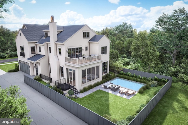 rear view of house with a garage, a fenced backyard, a chimney, concrete driveway, and a balcony