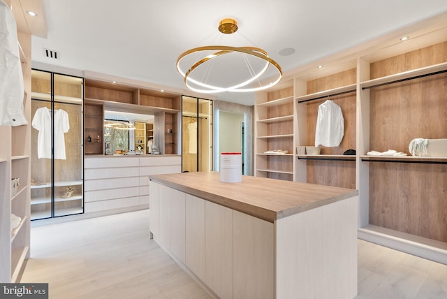 spacious closet featuring an inviting chandelier and visible vents