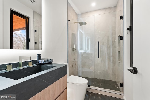 full bathroom with toilet, a stall shower, and vanity