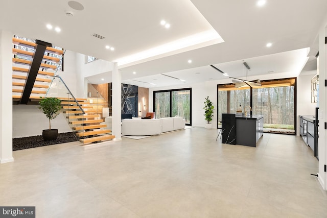 unfurnished living room featuring recessed lighting, stairs, concrete floors, and visible vents