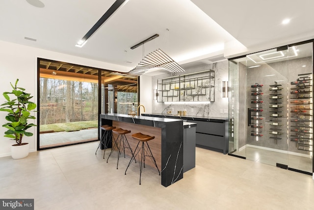 bar with indoor wet bar, visible vents, and baseboards