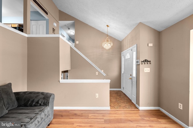 6011 Bauman Dr, Elkridge, MD 21075 - entrance foyer with stairs, wood finished floors, an inviting chandelier, baseboards, and lofted ceiling