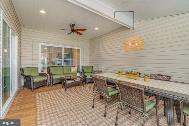 sunroom / solarium with outdoor dining space, a ceiling fan, and an outdoor hangout area