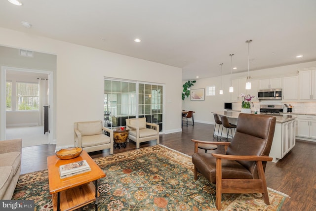 living room with dark wood-type flooring, recessed lighting, visible vents, and plenty of natural light