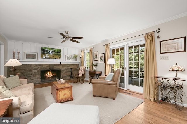 11836 Hunting Ridge Ct, Potomac, MD 20854 - living room with wood finished floors, a ceiling fan, ornamental molding, and a stone fireplace